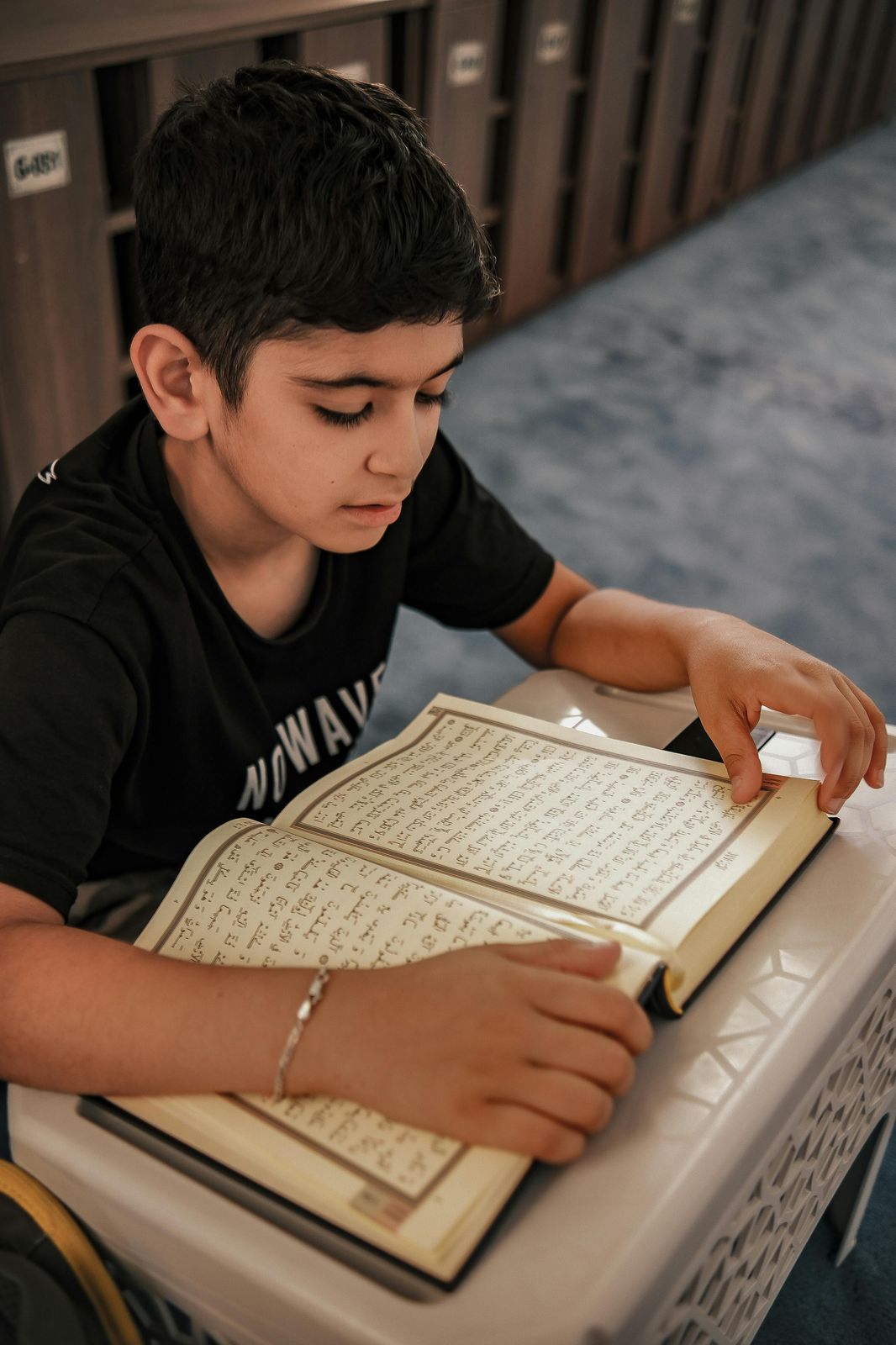 Teen boy reading and memorizing the Quran